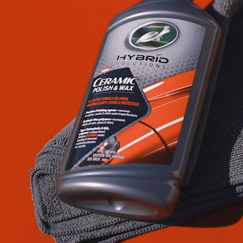 Turtle Wax Hybrid Solutions ceramic polish and wax for auto paint correction. The bottle rests on a gray detailing cloth.