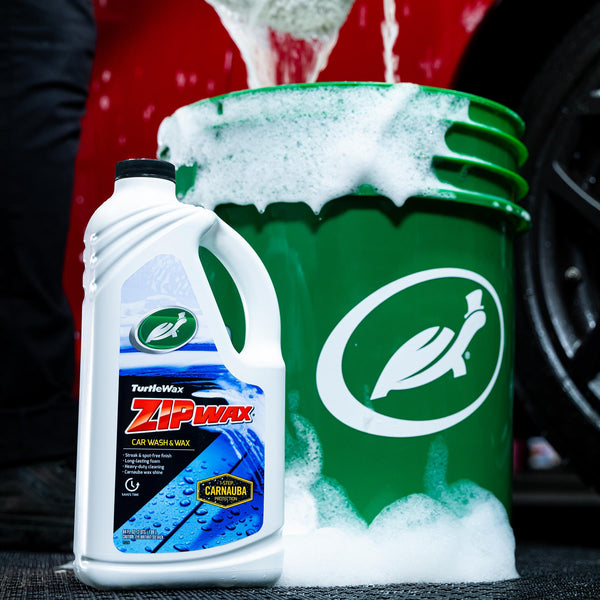 Turtle Wax Zip Wax Car Wash & Wax with a green bucket and plenty of suds. Car detailing supplies for a clean, shiny finish.