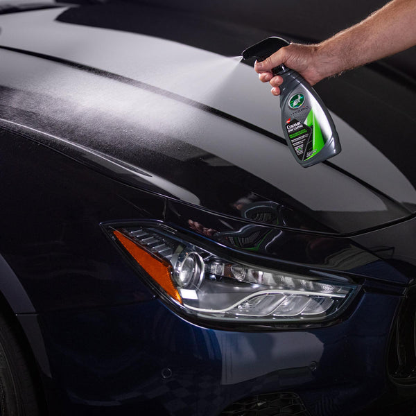 Detailing a car with Turtle Wax Hybrid Solutions ceramic spray for a shiny, protected finish.
