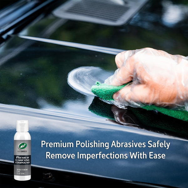 Auto detailing: Hand applies Turtle Wax clarifying compound to a glossy black car surface. Car care and paint correction shown.